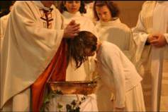 Des enfants en âge scolaire réunis autour des fonts baptismaux